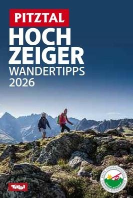 A family is hiking along a picturesque path in the mountains. The sky is clear and the landscape is green and inviting.