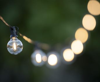 A light garland with glowing bulbs gently illuminates. The background is blurred, creating a cozy atmosphere.