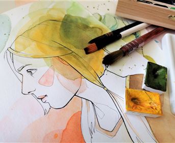 An artistic illustration of a woman with light hair, surrounded by watercolor paints. Brushes and color palettes lie next to the picture.