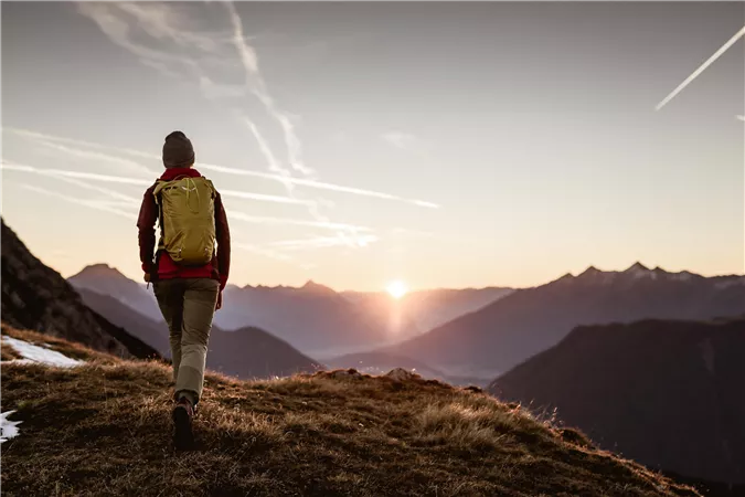 Ein typisches Haus in einer natürlichen Umgebung mit Felsen im Hintergrund. Der Bereich ist grün und von Bäumen umgeben.