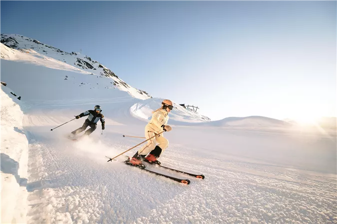Man and woman skiing on the Hochzeiger slopes.