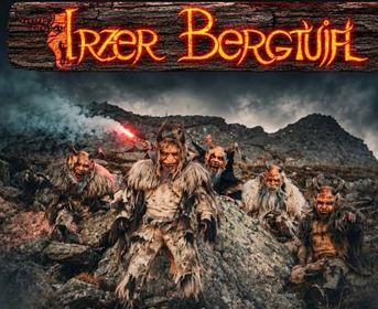 Eine Gruppe von furchterregend aussehenden Kreaturen in historischer Bekleidung steht auf einem steinigen Gelände. Die Atmosphäre ist düster und mystisch, umgeben von Bergen.