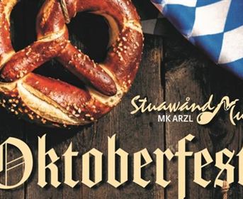 A large pretzel on a wooden table, surrounded by traditional Bavarian decoration. The inscription "Oktoberfest" highlights the festive atmosphere.