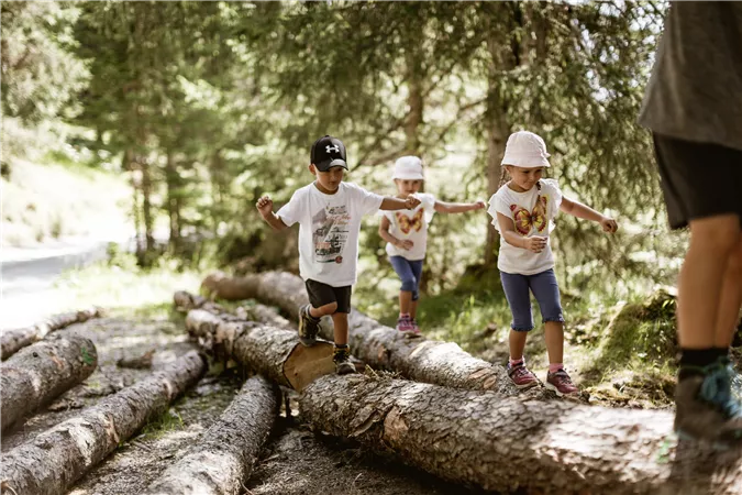 Ein typisches Haus in einer natürlichen Umgebung mit Felsen im Hintergrund. Der Bereich ist grün und von Bäumen umgeben.