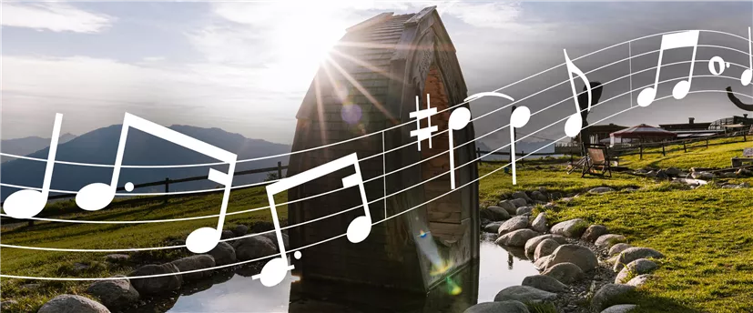 A picturesque landscape with a wooden structure and gentle hills. Musical notes are visible in the foreground.