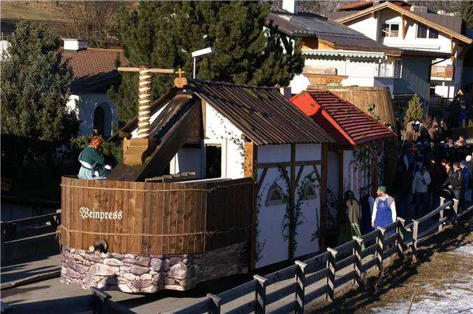 Ein traditionelles Holzgebäude mit einem roten Dach und einer kleinen Holzkonstruktion voran. Menschen stehen in der Nähe und genießen die Umgebung.