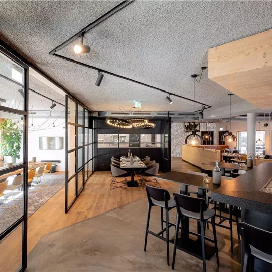 Ein modernes Restaurant mit eleganter Einrichtung und viel Licht. Der offene Bereich lädt zum Verweilen ein.