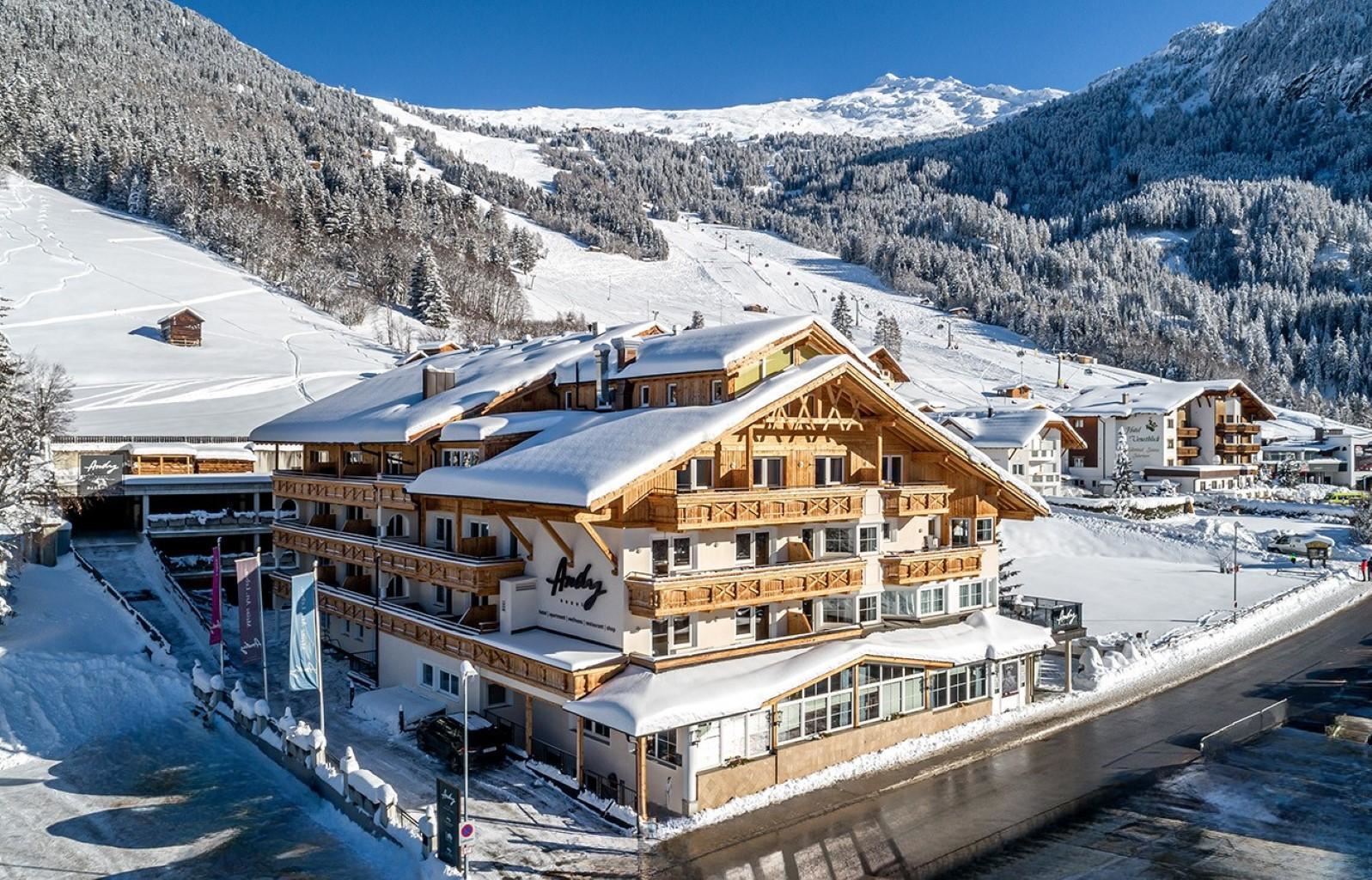 Ein gemütliches Hotel in den Alpen, umgeben von schneebedeckten Bergen. Die klare, kalte Winterluft schafft eine malerische Atmosphäre.