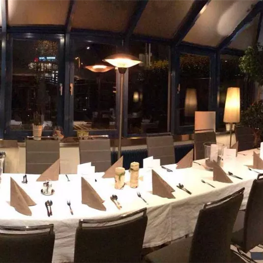 A stylish restaurant with elegant tables and chairs. The atmosphere is inviting and well-lit.