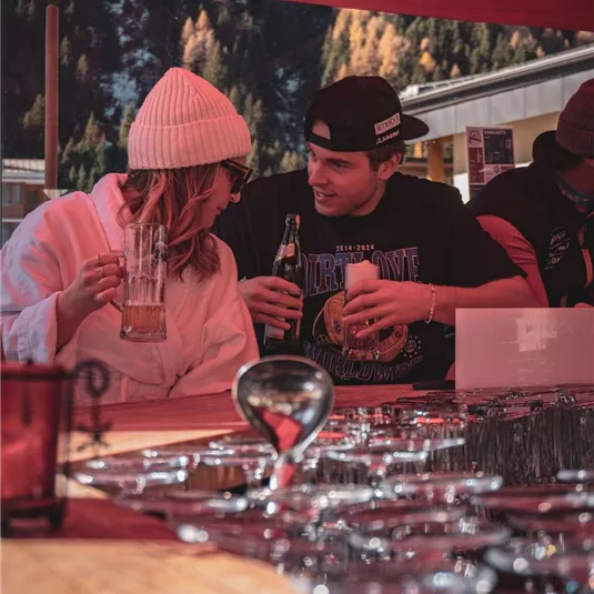 Ein Paar sitzt an einem Tisch und genießt Getränke. Die Atmosphäre ist entspannt und freundlich, mit einem klaren Blick auf die Umgebung.