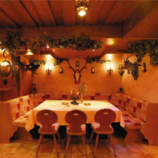 Ein gemütlicher Essbereich mit einer großen, gedeckten Tisch. Die Wände sind dekoriert und das Ambiente ist warm und einladend.
