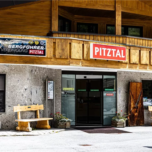 Ein traditionelles Gebäude im Pitztal mit einem Holzbalkon. Die Fassade zeigt ein Schild der Bergführer Vereinigung und den Namen Pitztal.