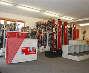 Ein Skigeschäft mit vielen Skiern und Ausrüstungen. Die Einrichtung ist modern und gut organisiert.