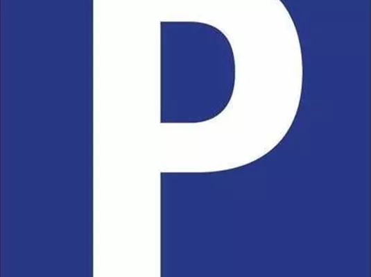 A sign with a large white "P" on a blue background. It indicates a parking lot.