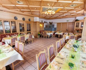 A cozy restaurant with wood decor and friendly-set tables. The atmosphere is inviting and warm.