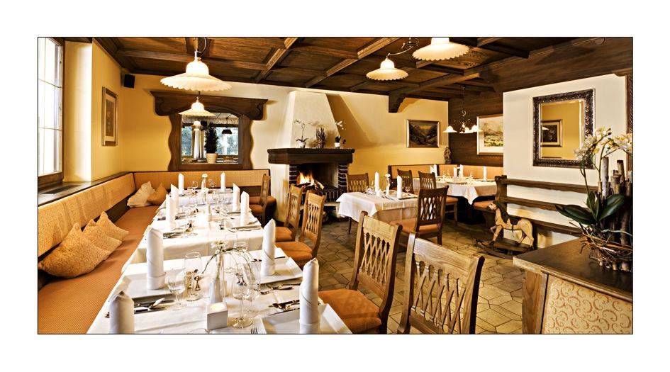 Ein stilvolles Restaurant mit Holzdekor und gemütlicher Atmosphäre. Die Tische sind elegant gedeckt und laden zum Verweilen ein.