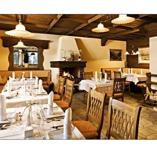 Ein stilvolles Restaurant mit Holzdekor und gemütlicher Atmosphäre. Die Tische sind elegant gedeckt und laden zum Verweilen ein.
