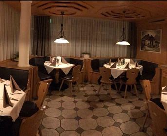 A cozy restaurant with elegant tables and soft lighting. The atmosphere is inviting and warm.