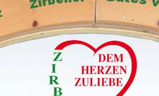 Ein gebogener Holzrahmen mit grüner Schrift, die verschiedene Produkte von der Zirbe anzeigt. In der Mitte befindet sich ein rotes Herz mit dem Text "DEM HERZEN ZULIEBE".