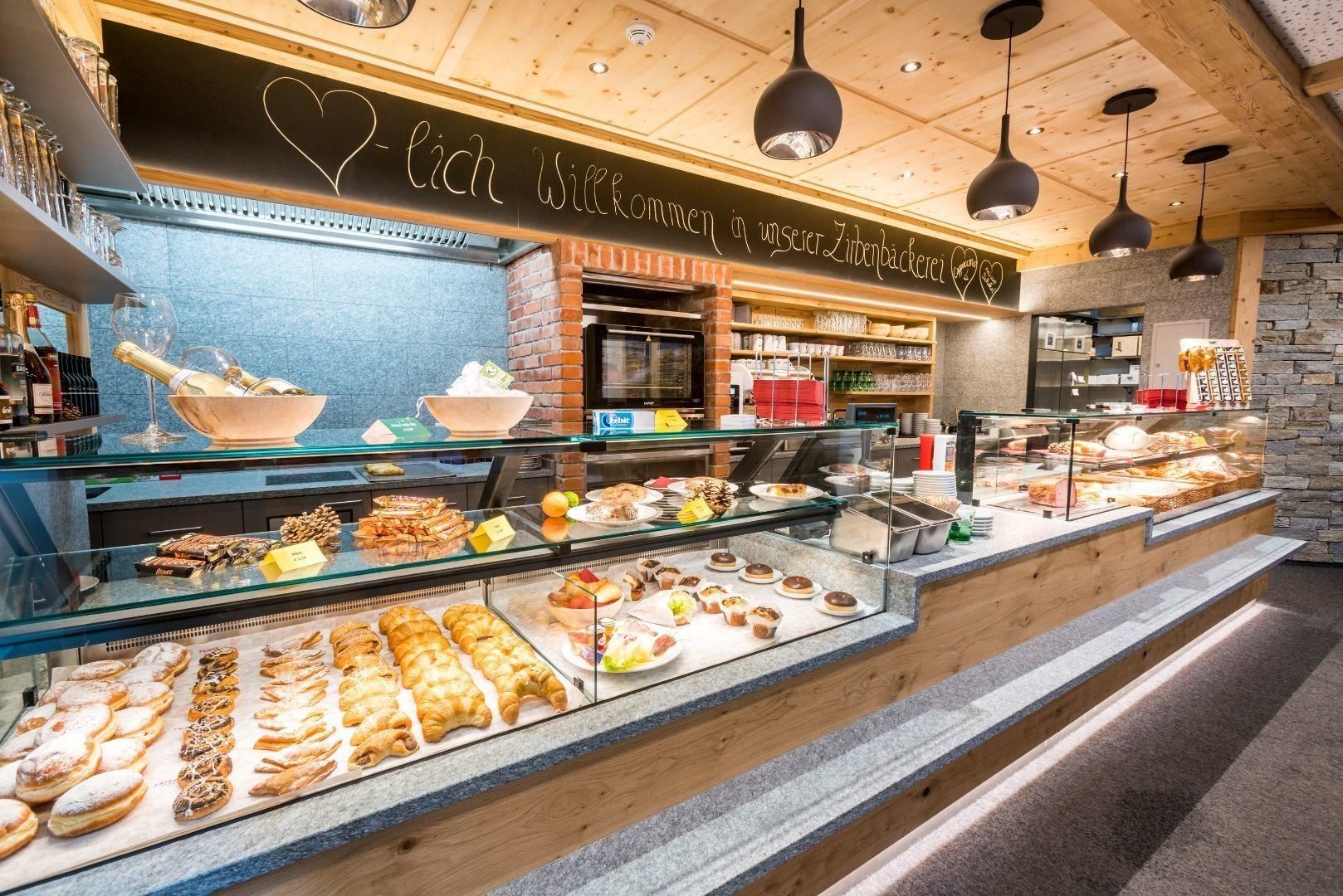 Ein einladender Backshop mit einer großen Auswahl an frischen Backwaren. Die Theke ist liebevoll dekoriert und bietet süße und herzhafte Leckereien.
