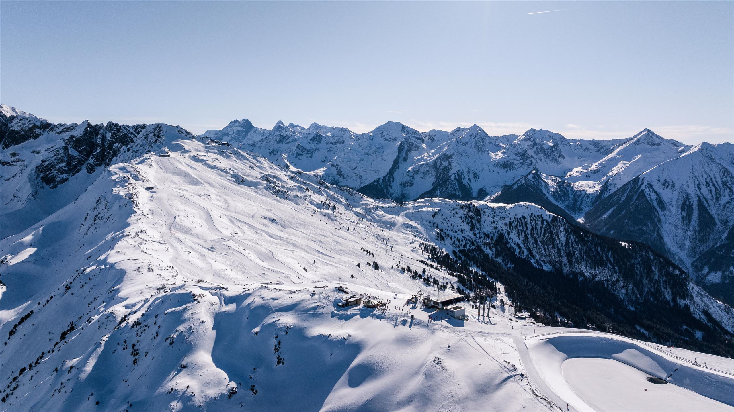 Eine beeindruckende Winterlandschaft mit schneebedeckten Bergen und klarem Himmel. Die Berggipfel erheben sich majestätisch über die Umgebung.