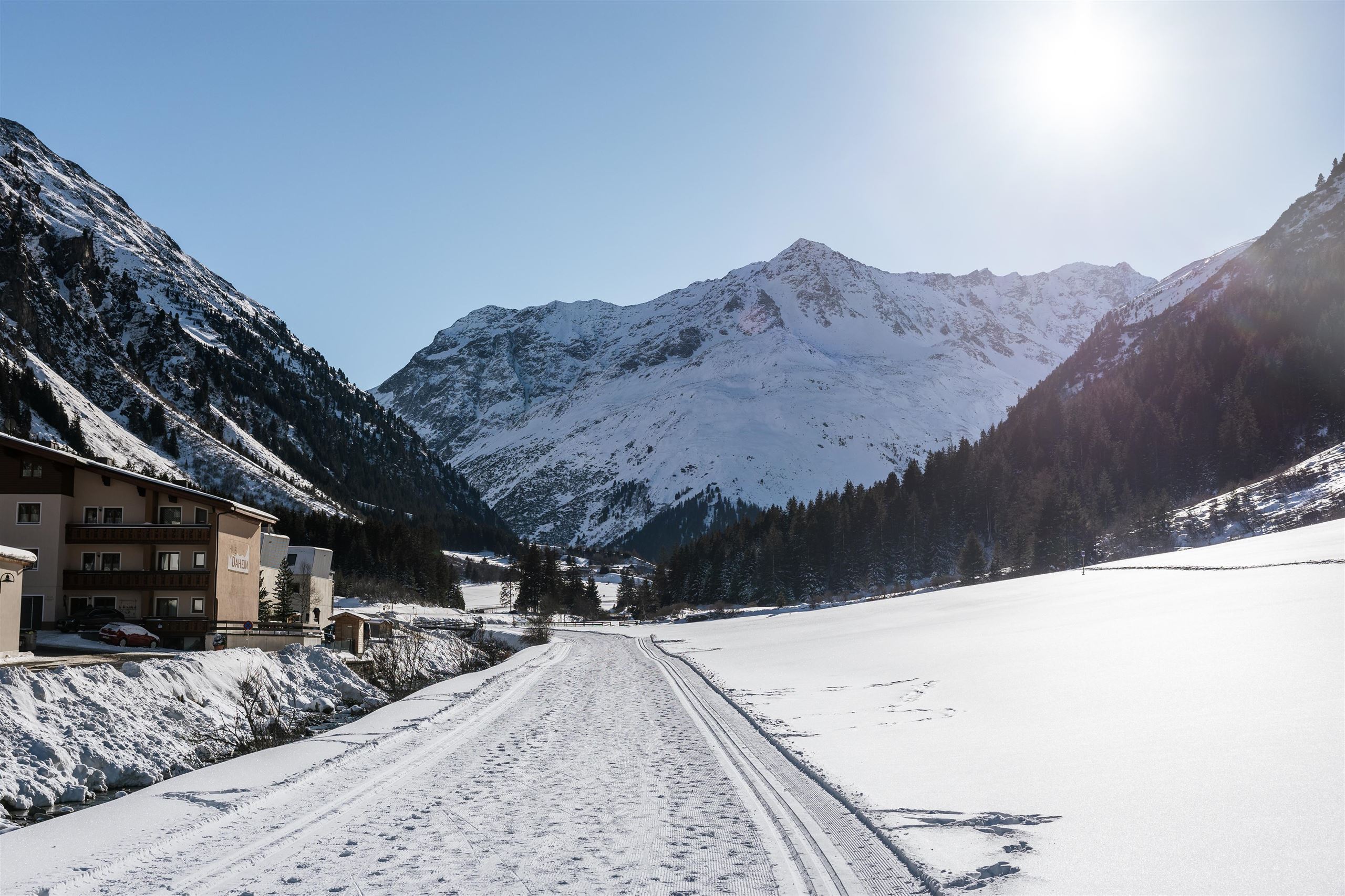 Ein malerisches Schneeapsühls von Bergen und einem klaren Himmel. Der Weg führt durch eine wunderschöne Winterlandschaft.