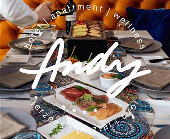 A beautifully set table with a selection of food and drinks. In the background, there is a stylish decor featuring an orange sofa.