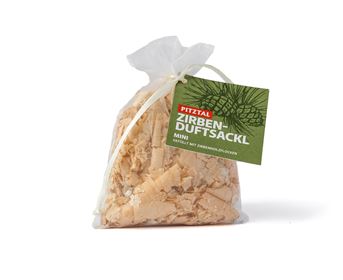 Ein kleiner Beutel mit Zirbenholzspänen, verpackt in einem durchsichtigen Stoffbeutel. Der Beutel hat ein grünes Etikett mit dem Namen "Zirben-Duftsäckl".