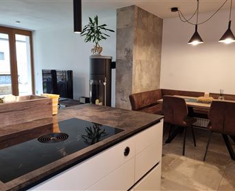 Modern kitchen with a cooking island and elegant furniture. The open dining area is bright and inviting.