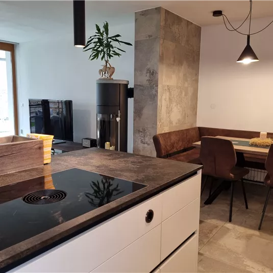 Modern kitchen with a cooking island and elegant furniture. The open dining area is bright and inviting.
