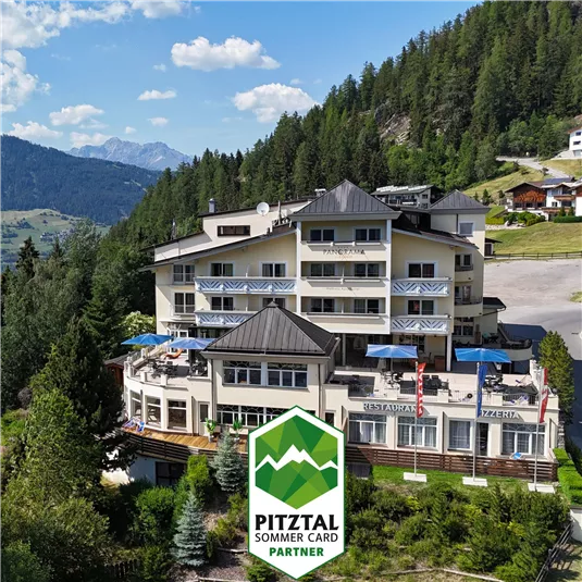 Ein panaromatisches Hotel umgeben von Bäumen und Bergen. Die Terrasse hat blaue Sonnenschirme und bietet einen schönen Blick auf die Landschaft.