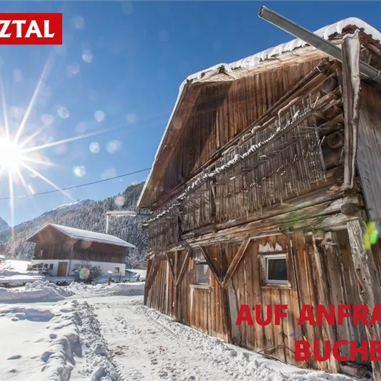 A rustic wooden house in the snow, surrounded by mountains and sunshine. Perfect for a winter vacation in Pitztal.