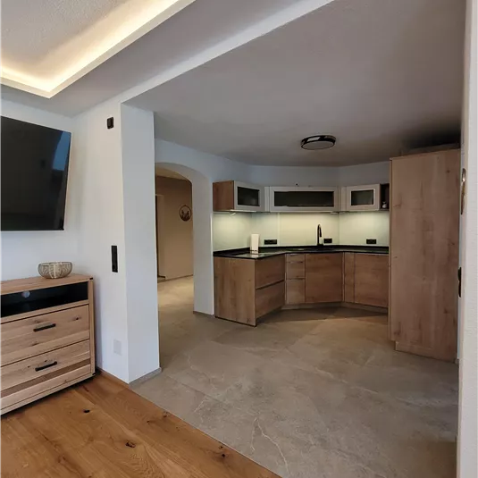Moderne Küche mit Holz- und Steinoberflächen. Helle, einladende Atmosphäre mit natürlichem Licht.