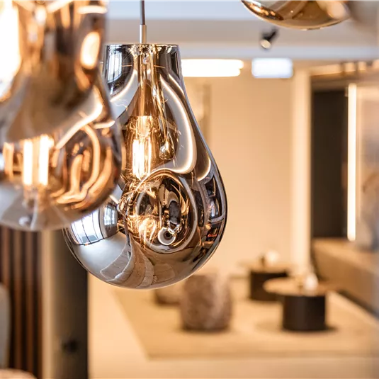 A modern interior decor with elegant, reflective lamps. The room looks stylish and inviting.