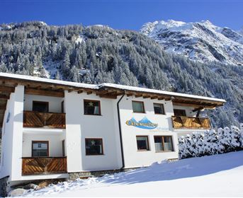 A charming building in the snow, surrounded by picturesque mountains. The clear winter air and the snowy landscape invite you to linger.