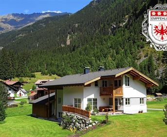 Ein modernes Haus in einer idyllischen Berglandschaft. Umgeben von grünen Wiesen und Bergen bietet es eine ruhige Atmosphäre.