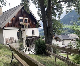 Ein charmantes Haus in den Bergen mit einem schönen Ausblick. Grüne Landschaft und ruhige Atmosphäre umgeben die Umgebung.