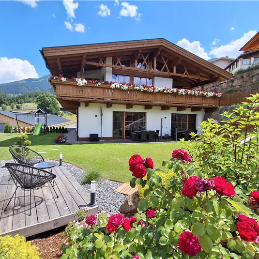 A modern house with a large garden and a balcony. Colorful flowers and a beautiful landscape surround the accommodation.