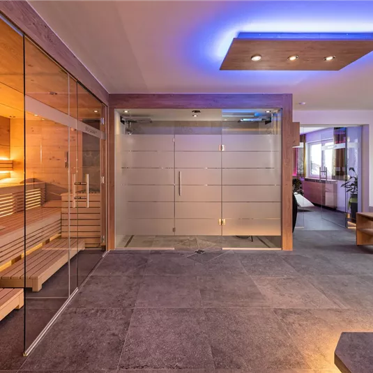 A modern sauna with warm wood and gentle lighting. The room is bright and inviting, ideal for relaxation.