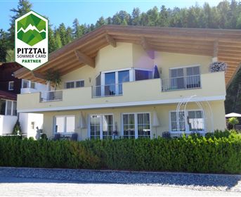 A modern house with a bright facade design and a large balcony. Surrounded by well-maintained trees, it presents itself in a picturesque setting.