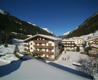 Eine schöne Winterlandschaft mit schneebedeckten Bergen und einem gemütlichen Hotel. Die Umgebung ist ruhig und malerisch mit viel Schnee.