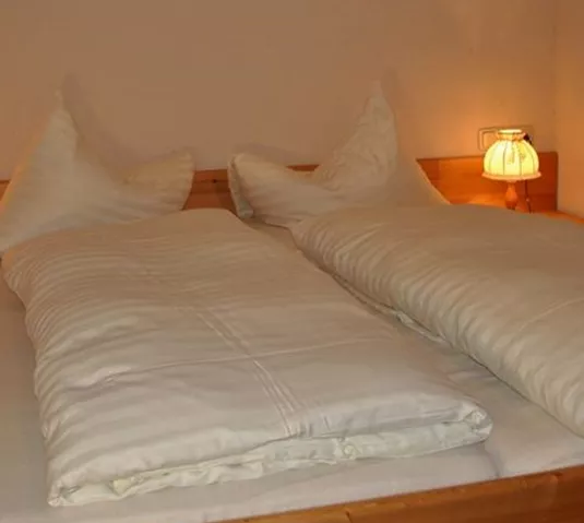 A cozy bedroom with a double bed and two nightstands. The warm lamps create an inviting atmosphere.